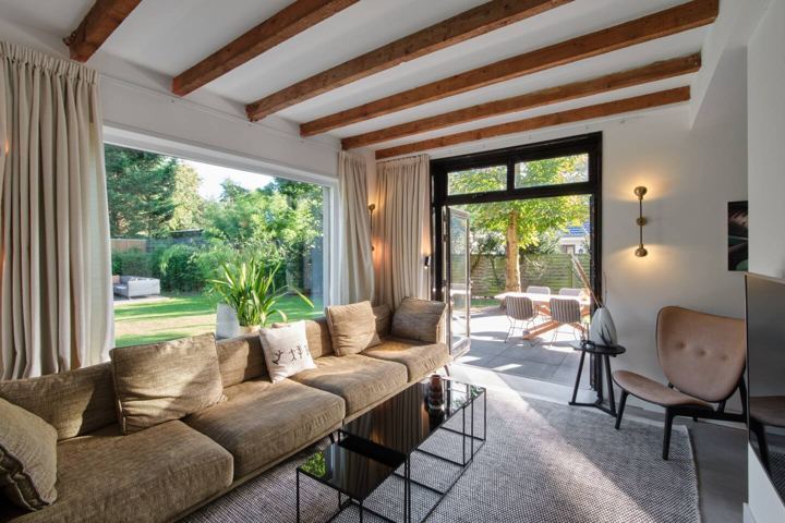 Wohnzimmer mit Loungesofa und Gartenblick